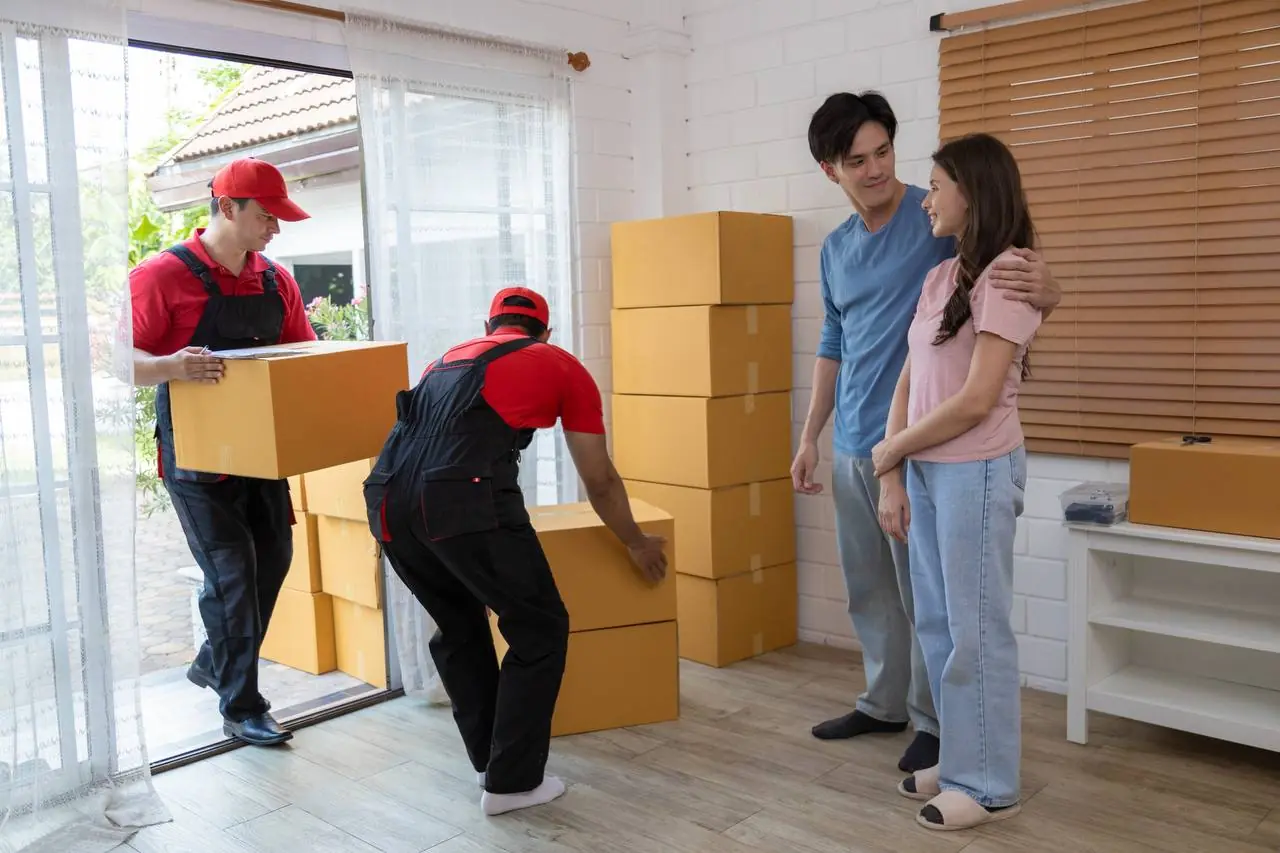 Professional movers carrying boxes outside home for interstate relocation