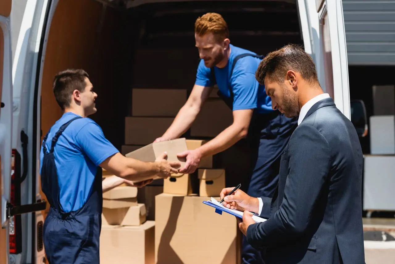 Movers carefully wrapping fragile items for state to state transport