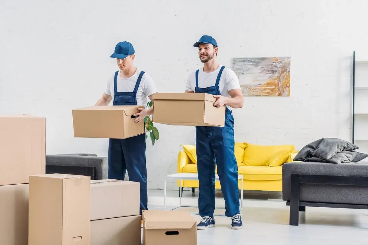 Professional movers carrying boxes through a home during a residential move