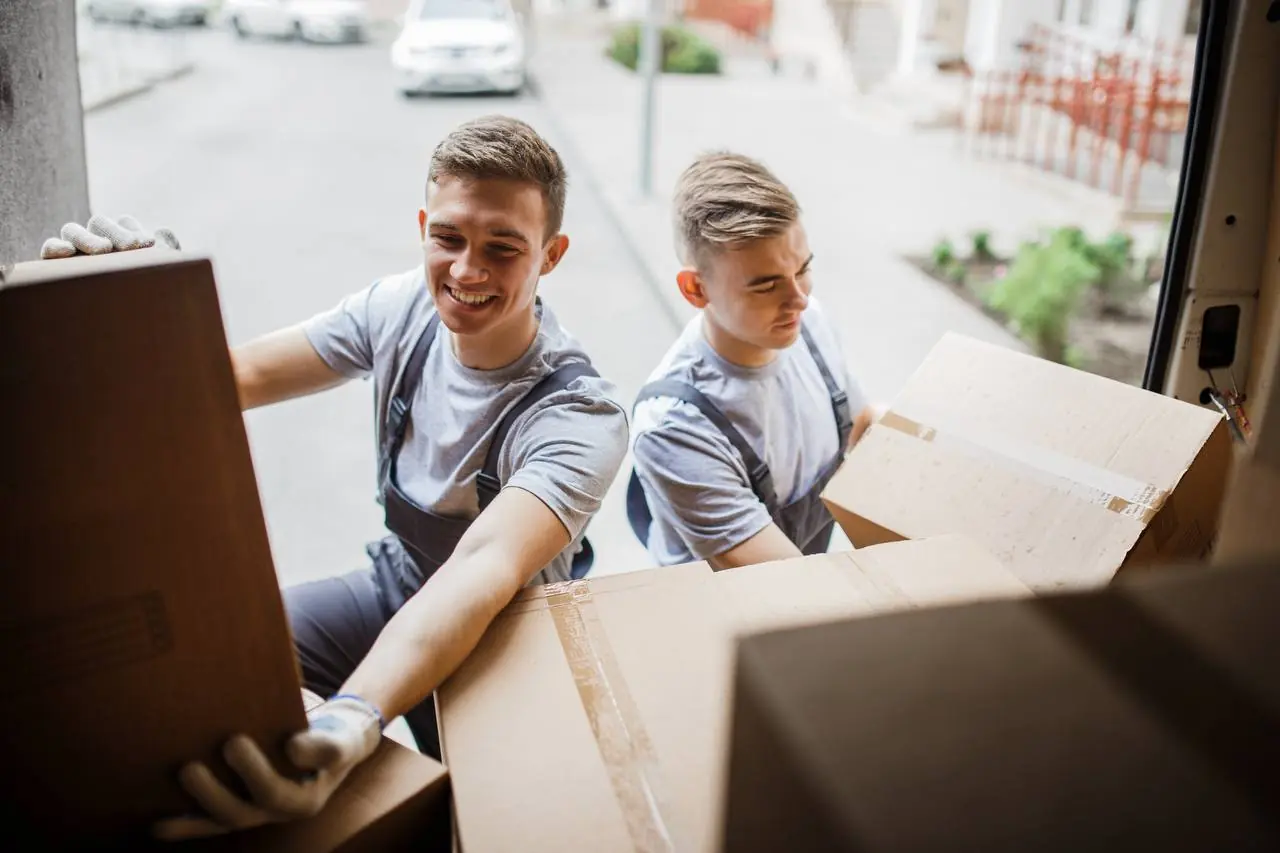 Professional movers wrapping sofa for out of state transport